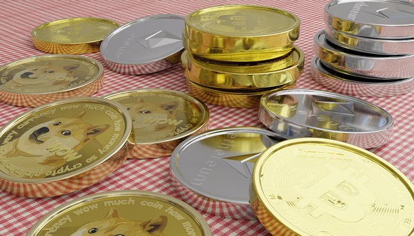 Bitcoin, Ethereum, and Dogecoin-style coins on a table representing cryptocurrencies used to buy Monero