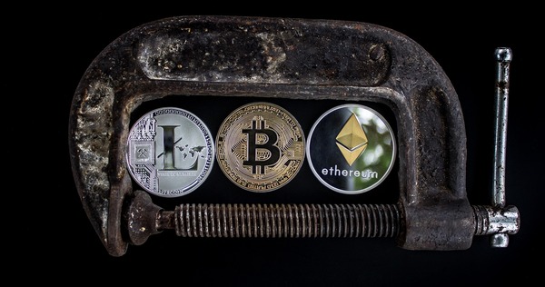 Litecoin, Bitcoin, and Ethereum coins clamped together representing multiple cryptocurrencies for Monero exchange