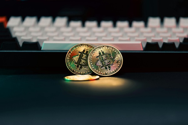 Physical bitcoin-style cryptocurrency coins resting on a computer keyboard, symbolizing digital currency basics